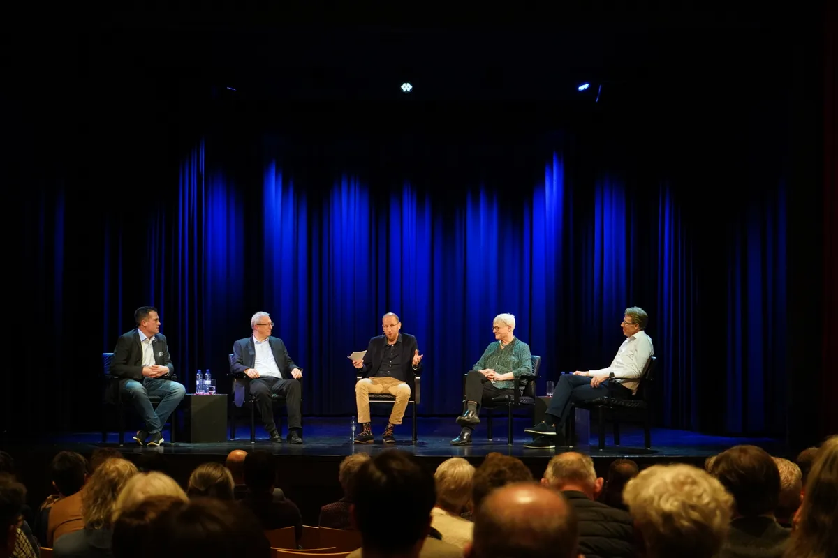 Politikerinnen und Politiker sind auf der Bühne und beantworten Fragen.